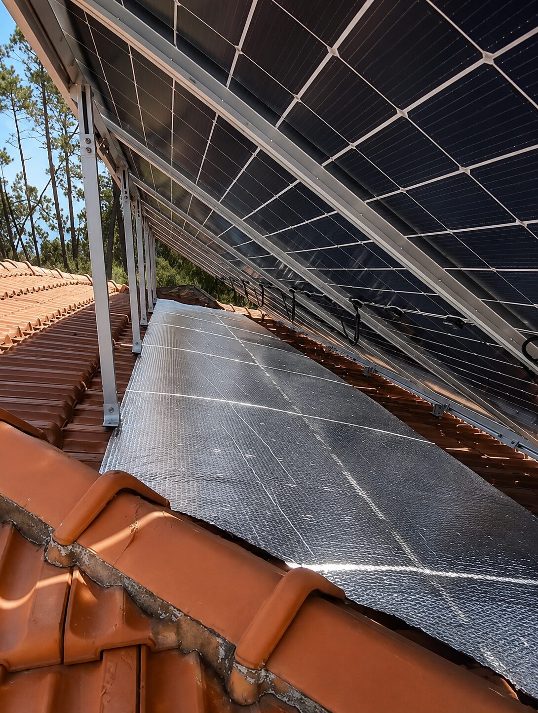 Painéis solares em telhado inclinado junto a mata