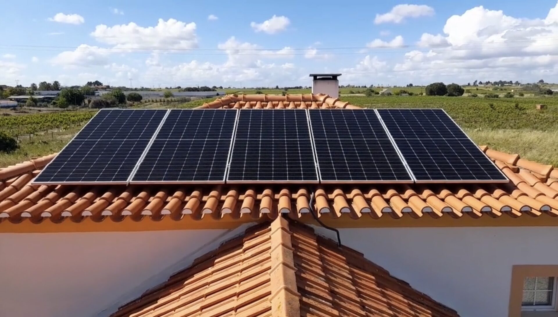 Painéis solares em telhado de telha cerâmica, junto a vinha
